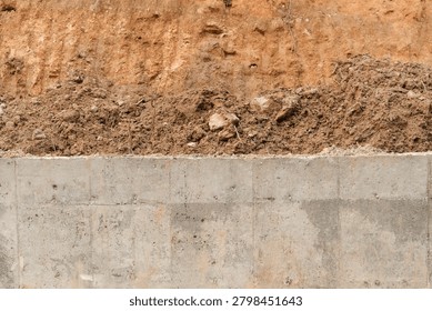 Abstract composition divided equally between compact concrete and orange excavated soil textures. Ideal for backgrounds, banners and construction-themed graphic designs.