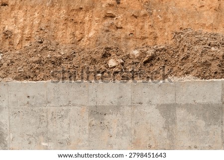 Abstract composition divided equally between compact concrete and orange excavated soil textures. Ideal for backgrounds, banners and construction-themed graphic designs.