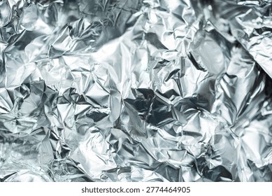 Abstract composition featuring a close up of crumpled aluminum foil with reflective highlights and deep shadows.
