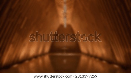 Abstract composition featuring warm glowing light streaks and reflections on a dark surface, creating a sense of depth and movement.