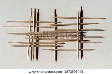 An abstract composition of toothpicks. The poster is in a bleached technique.