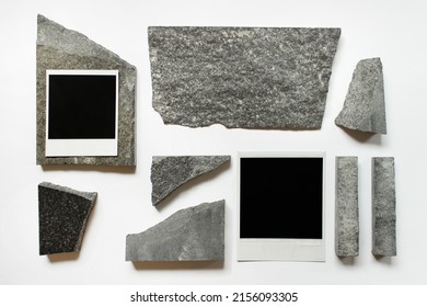 Abstract composition with two polaroid cards and random sized stones on white background.