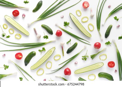 Abstract Composition Of Vegetables. Vegetable Pattern. Food Background. Top View. Large And Small Cucumbers, Garlic, Tomatoes And Green Onions On A White Background. Food Concept. Sliced Vegetables.