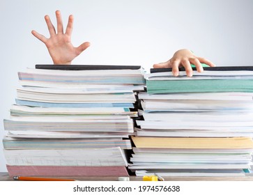 Abstract Concept Image Showing A Young Student Behind A Large Pile Of Test Prep Books On A Study Desk. An Overwhelming Load. The Kid Is Trying To Escape By Climbing Onto The Pile As If She Is Drowning