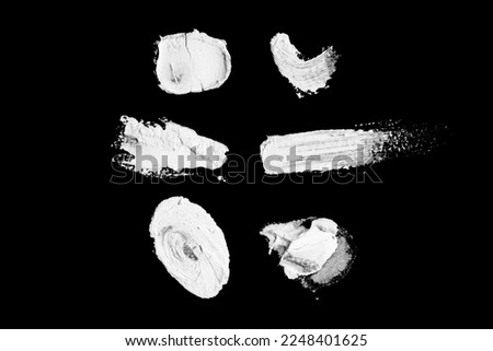 Abstract cream stroke of white paint. Raw thick white color dye imprint. Isolated on black background.