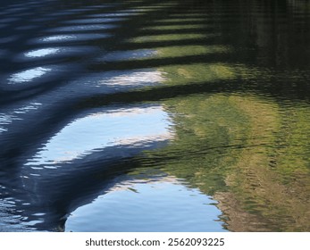 Abstract created by a sightseeing boat wake as it cruises on a fjord in Norway. Green hillsides and blue sky are reflected in the water. - Powered by Shutterstock