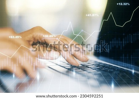 Abstract creative financial graph with hand typing on laptop on background, forex and investment concept. Multiexposure