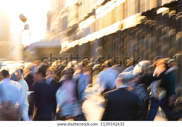 Abstract crowd of people walking down a sunny urban\
street in New York\
City