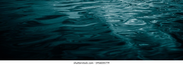     Abstract dark blue green background. Reflection of sunlight on a wavy water surface. Beautiful teal background with copy space for design. Web banner.                            - Powered by Shutterstock