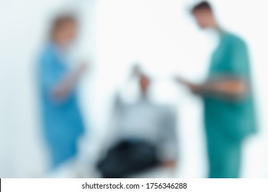 Abstract Defocus Motion Blur Of Medical Doctor Team Visiting And Health Patient In Examination Room, Silhouette Blurred Of Doctors Teamwork While Consulting Their Senior Patient In Hospital Clinic.