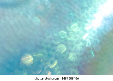 Abstract Defocused Shiny Iridescent Turquoise Background. Futuristic Holographic Texture With Light Purple And Yellow Bokeh.