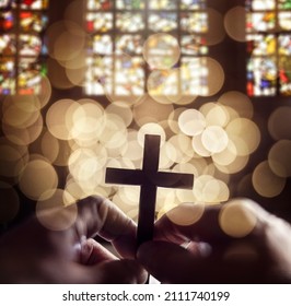 Abstract defocussed crucifix cross silhouette in church interior against stained glass window concept for religion worship and prayer