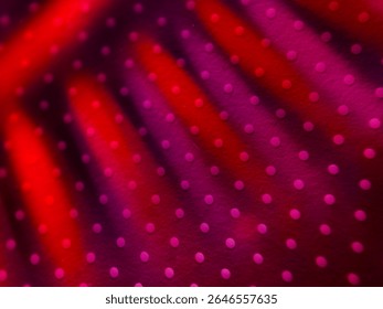 An abstract design featuring a blend of red and purple hues with a dotted texture.