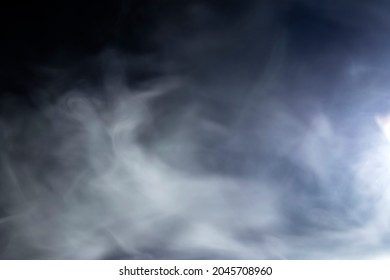 Abstract design of white cloud on a dark background. Blurry motion of smoke.