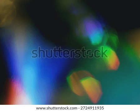 An abstract display of vibrant light reflections and refractions creates a mesmerizing visual composition. The image features a spectrum of colors—deep blues, purples, bright greens, yellows, and reds—blending seamlessly in soft gradients and intersecting geometric shapes. These luminous patterns appear to be formed by light interacting with a faceted or translucent surface, such as glass or crystal. The interplay of color, light, and shadow evokes a sense of motion and depth, making the image both dynamic and captivating.
