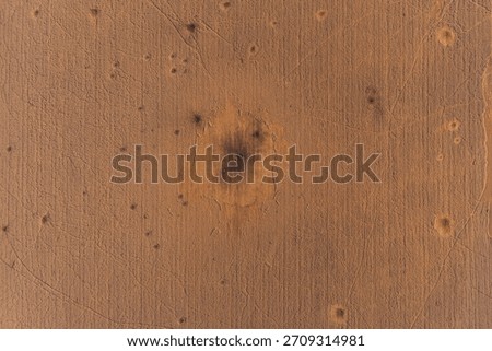 Abstract drone shot capturing a fresh, dark impact crater from a guided aerial bomb in a field. The scorched earth and scatter pattern illustrate the brutal reality of military conflict.