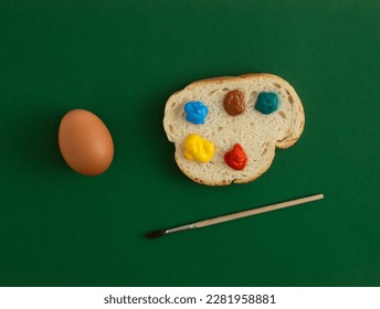 Abstract Easter composition made of egg and slice of bread with colorful palette. Green background. Topy view, flat lay.  - Powered by Shutterstock