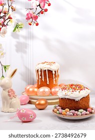 Abstract Easter composition with traditional Russian kulich with meringue and decorated eggs on elegant kitchen table with spring sakura flowers. Happy Easter concept