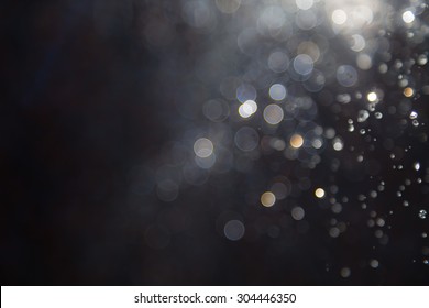 Abstract elegant glitter sparkle bokeh defocused on black background