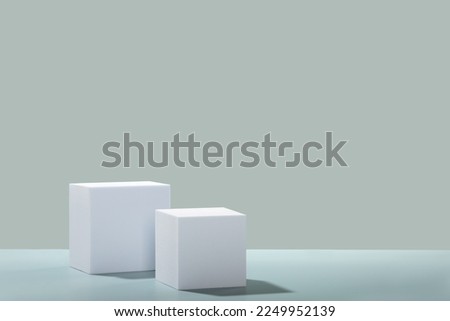 Abstract empty white cubes podiums with eucalyptus leaves and shadows on blue background. Mock up stand for product presentation. 3D Render. Minimal concept. Advertising template, copy space