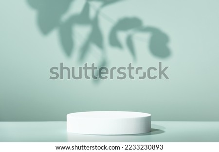 Abstract empty white podium with leaves shadows on blue background. Mock up stand for product presentation. 3D Render. Minimal concept. Advertising template