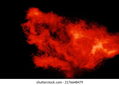 Abstract Explosion Of Orange Dust On Black Background.Freeze Motion Of Orange Powder Burst.