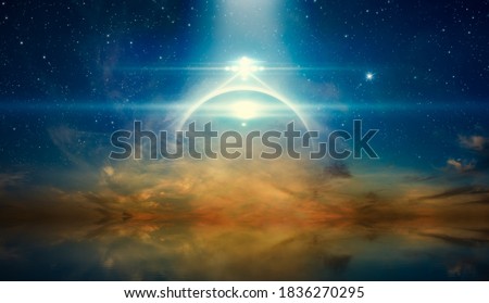 Abstract fantastic image - bright mysterious extraterrestrial lights or UFO shine over glowing horizon. Stars and a powerful searchlight in dark blue sky. Sea is calm below.