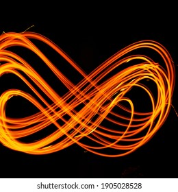Abstract fiery pattern in the shape of the number 8. Drawing shapes with fire at night, infinity sign, bright colors on night background, fun with fire.