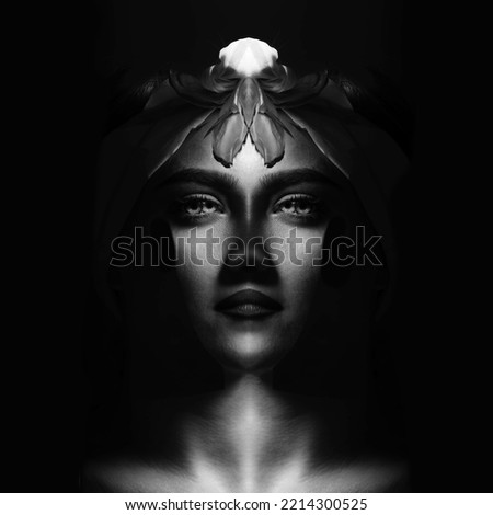 Abstract, fine art, sci-fi concept. Abstract and futuristic looking woman portrait. Alien or extraterrestrial looking model with hair, eyes and lips looking calmly at camera. Black and white image