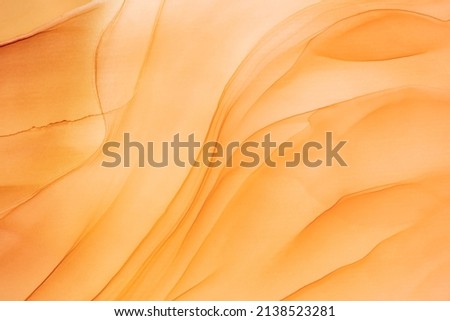 Abstract fluid art painting in alcohol ink technique. Flowing translucent paint warm hues. Background similar to the landscape of movement sands. Designed for wall art, postcard or poster, cover.