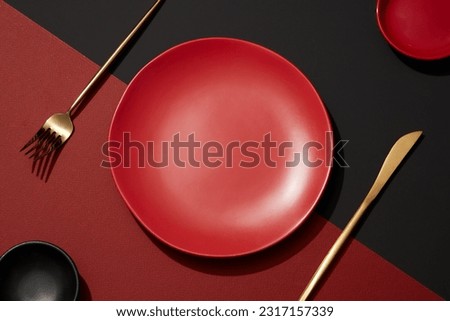 Abstract food background with eating utensil. Top view of an empty round red plates and cutlery decorated on red and background. Setting table for dinner with minimal concept
