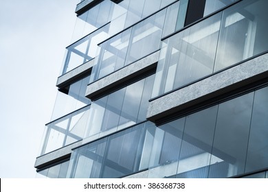 Abstract fragment of modern architecture, walls made of glass and concrete. Blue tonal filter photo effect - Shutterstock ID 386368738