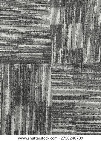 Abstract geometric carpet texture featuring a patchwork pattern of square tiles in shades of grey and black. The design combines linear striations and subtle tonal variations, creating a modern, minimalist surface ideal for interior design concepts, backgrounds, and architectural visuals.