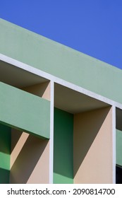 Abstract Geometric Pattern Background Of Shading Fin Concrete On Modern Green And Beige Building Wall Against Blue Clear Sky In Vertical Frame