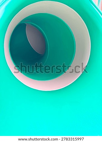 Abstract geometric view inside a bright mint green plastic tunnel slide with copy space