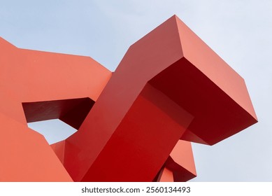 Abstract geometry of red architectural structure with clear sky