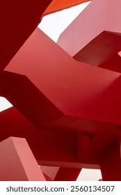 Abstract geometry of red architectural structure with clear sky