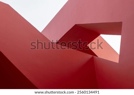 Abstract geometry of red architectural structure with clear sky