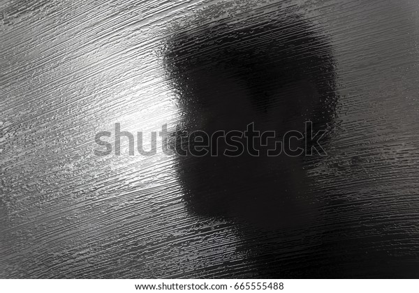 Abstract glass texture of room divider with\
silhouette of man