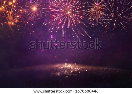 abstract gold and purple glitter background with fireworks. christmas eve, 4th of july holiday concept