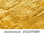 Abstract gold texture background with laser-etched rock wall, golden color, top view, close-up