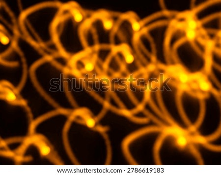 Abstract golden loop light trails with soft bokeh blur created by intentional camera movement (ICM) on a dark background, featuring glowing circular patterns and warm luminous curves ideal for festive, motion, energy, and abstract design backgrounds.