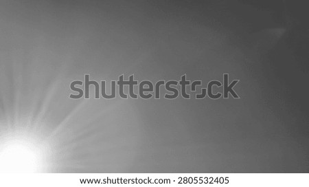 Abstract grayscale background featuring a sunburst effect with light rays emanating from the lower left corner.