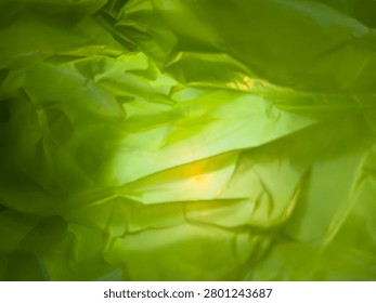 An abstract green background with intricate patterns, reflecting light from the background and in the center.