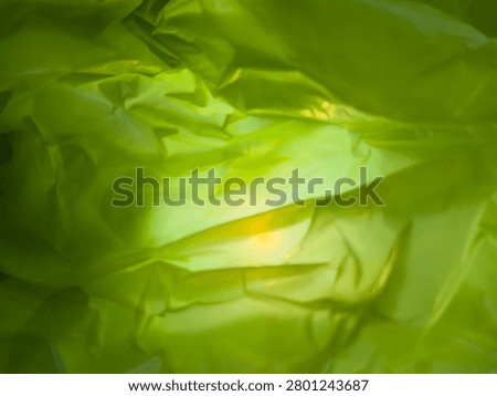An abstract green background with intricate patterns, reflecting light from the background and in the center.