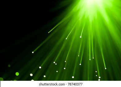 Abstract green fibre optic light strands against a black background.