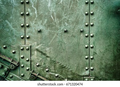 Abstract green industrial metal background texture with bolts and rivets. Old painted metal background, detail of military aircraft, surface corrosion, metal texture with rivets