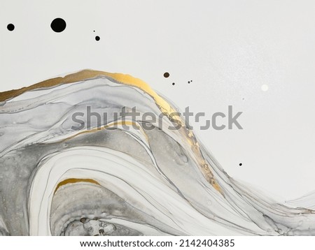 Abstract grey art with gold — black and white background with beautiful smudges and stains made with alcohol ink and golden paint. Grey fluid texture resembles marble, smoke, watercolor or aquarelle.