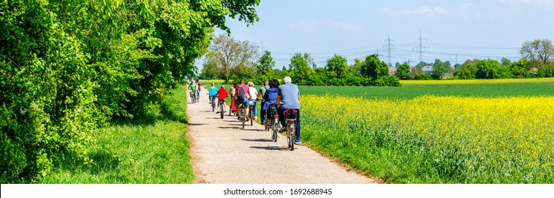 Abstract group of cyclists riding on road in springtime, banner