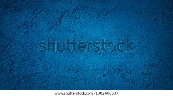 抽象的グランジ装飾レリーフネービー青の塗り壁のテクスチャー スポットライトの付いた広角の粗い色の背景 暗い背景とデザイン用のコピースペース の写真素材 今すぐ編集
